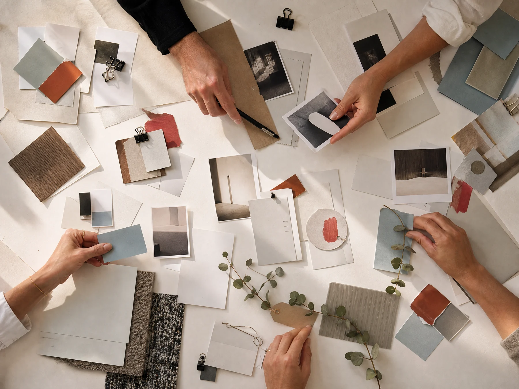 Hands sorting project artefacts and career evidence on a white table